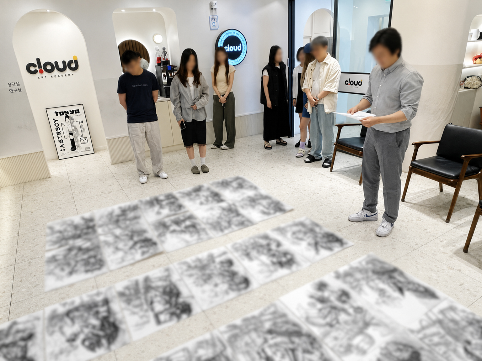 실기원장과 전임강사 선생님이 학생들이 그린 기초소양 작품을 함께 품평하는 장면
